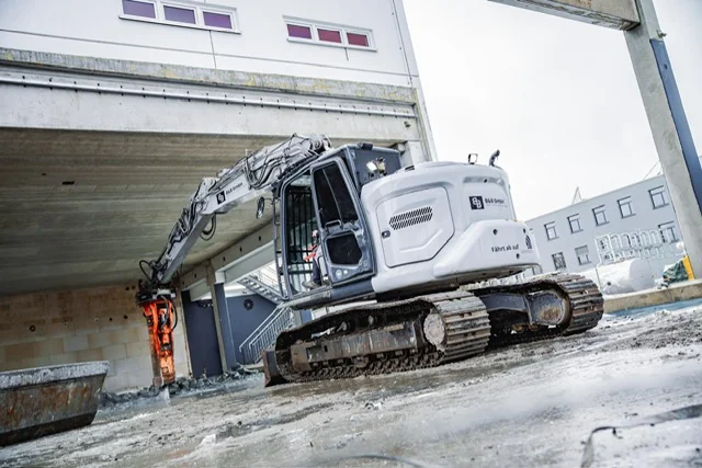 Bagger mit Abbruchhammer unter einem Brückenbauwerk