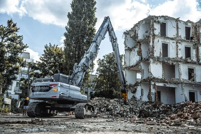 Bagger neben einer freigelegten Gebäudefassade